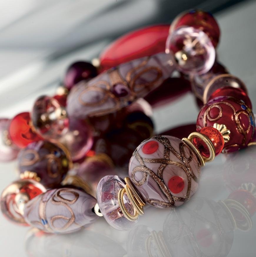 Close-up of a bracelet of rose and ruby Murano glass beads